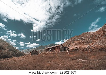 Unfinished Lonely Forsaken Wooden House Surrounded By Hills With Meadow In Foreground; Abandoned Dil