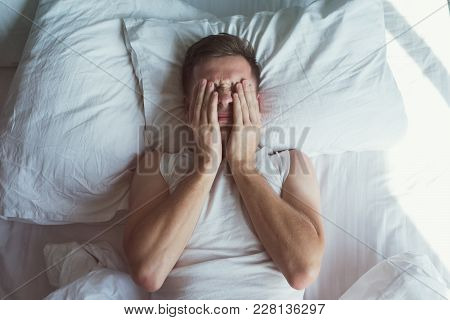 Caucasian Young Man Closed Eyes With Hands. He Is Desperate And Worries About Problem While Sleeping