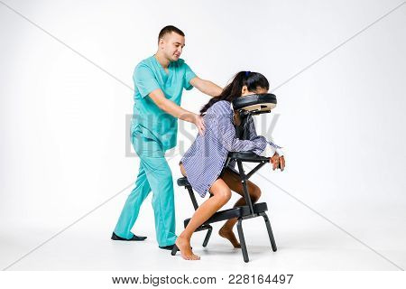 Theme Massage And Office. Male Therapist With Blue Suit Doing Back And Neck Massage For Young Woman 