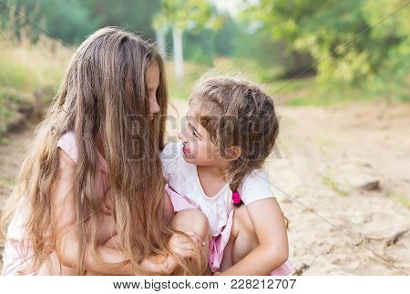 Beautiful Young Girls With Long Hair, Smiling And Talking At Summer Day. Having Fun Otdoors