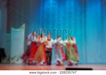 Folk Dances Of Children And Teens Theme Abstract Blur Background With Bokeh Effect. Teens In Bright 
