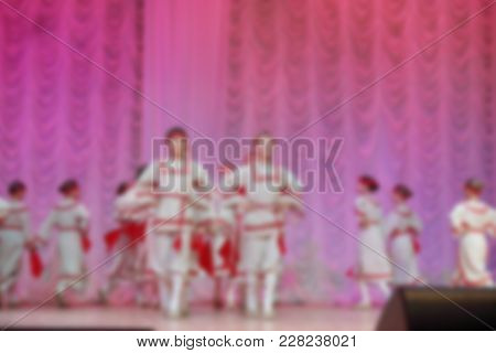 Folk Dances Of Children And Teens Theme Abstract Blur Background With Bokeh Effect. Teens In Bright 