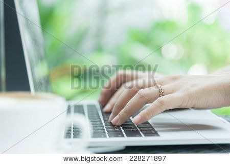 Asian Woman Hands And Married Ring Has Touching And Typing On Laptop Computer With Blurred Coffee, C