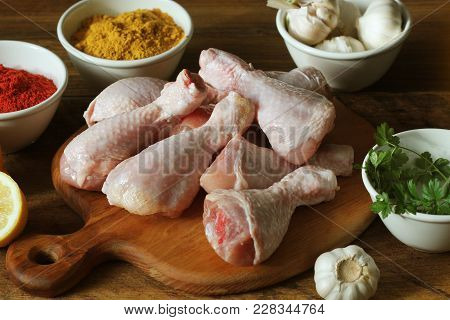 Raw Uncooked Chicken Legs, Drumsticks On Cuttingn Board, Meat With Ingredients For Cooking