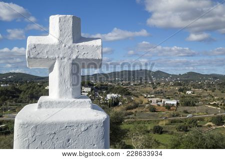 White Cross And Landscape In Santa Eularia Des Riu, Ibiza, Spain.