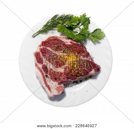 Raw Pork Steak On White Plate. White Background. The View From The Top