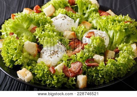 French Lyons Lyonnaise Salad With Lettuce, Croutons And Poached Eggs Close-up On A Plate. Horizontal