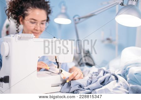 Side View Photo Of Sewing Machine And Dressmaker In Working Process. Sewing Business. Needlework
