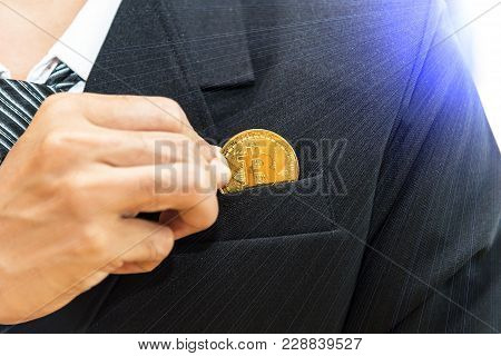 Cryptocurrency And Business. Businessman In Black Suite Holding Golden Coin Of Btc. Clodeup View Wit