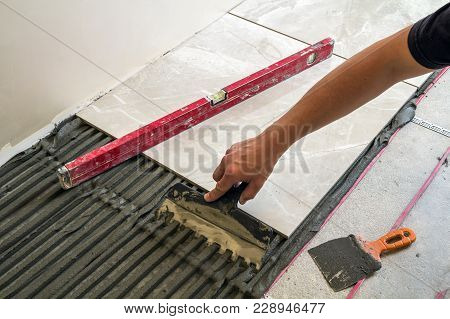 Ceramic Tiles And Tools For Tiler. Worker Hand Installing Floor Tiles. Home Improvement, Renovation 