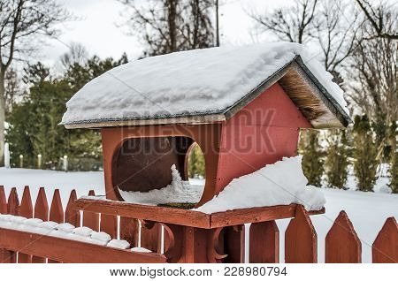 Large Red Feeder With Snow In Winter