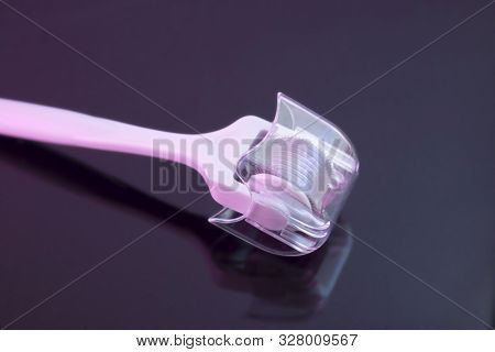 Mezoroller, Dermaroller, Mesotherapy Skin Tool. A Mesoroller With A White Handle And A Pink Rabbit O