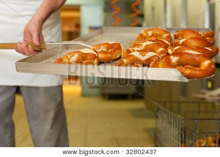 padeiro em pé na sua padaria na parte da manhã e assa pão ou pãezinhos