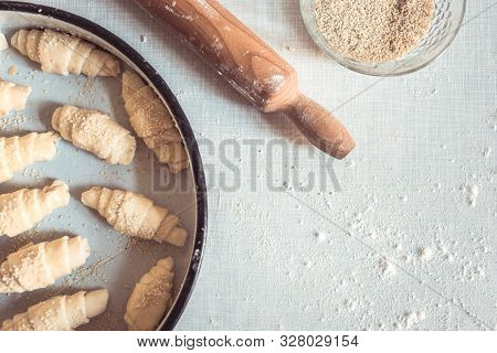 Top View Of Unbaked Rolls On The Table With Dough Roller. Process Of Making Crescent Rolls