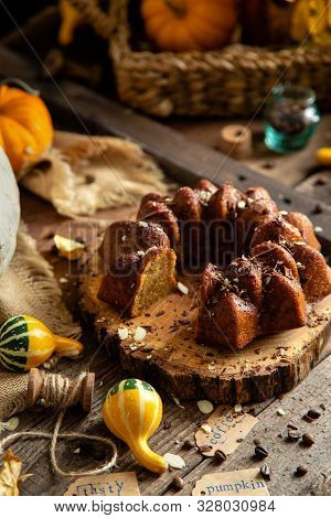 Tasty Homemade Baked Pumpkin Bundt Cake With Chocolate On Top Stands On Wooden Board On Rustic Table