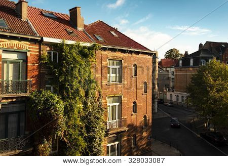 Brick House Covered In Luscious Vegetation In Central Brussels At Golden Hour