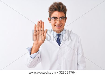 Young handsome sciencist man wearing glasses and coat over isolated white background Waiving saying hello happy and smiling, friendly welcome gesture