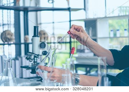 Womenscientist Looking Through Microscope In Laboratory. Women Scientist Doing Some Research With Dr