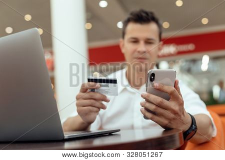 Man Using Smartphone And Laptop Computer For Online Shopping . Credit Card