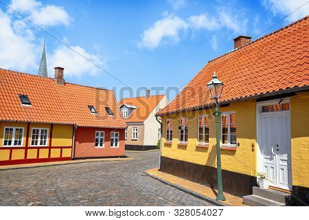 Street With Yellow Buildings And Cooblestone On The Road Under A Blue Sky