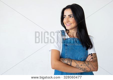 Joyful Attractive Young Brunette With Crossed Arms. Cheerful Brunette Lady Looking Aside On Light Ba