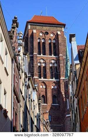 Bell Tower Of Gothic Basilica Of The Assumption Of The Blessed Virgin Mary Seen From Narrow Street K