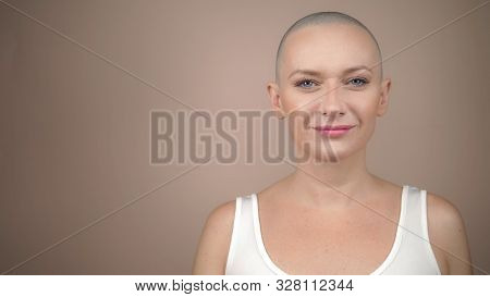 Beautiful Bald Woman Holds A Pink Ribbon In Her Hands. Gentle Pastel Background.