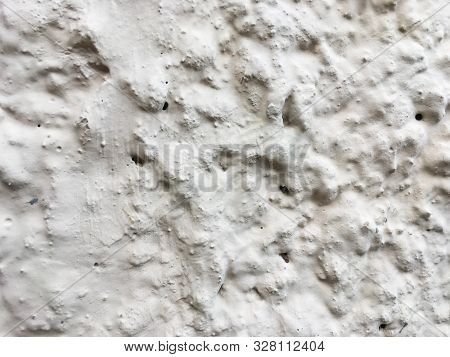 Uneven Concrete Wall Covered With White Paint.