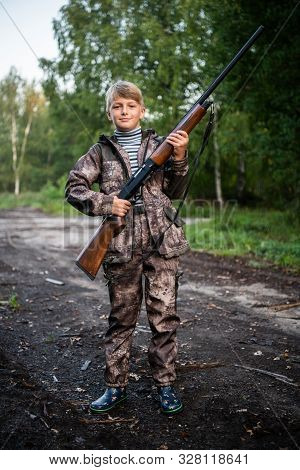 Father Gave A Son A Shotgun Rifle To Carry. Happy Boy Prepared For Hunding With His Father Together.