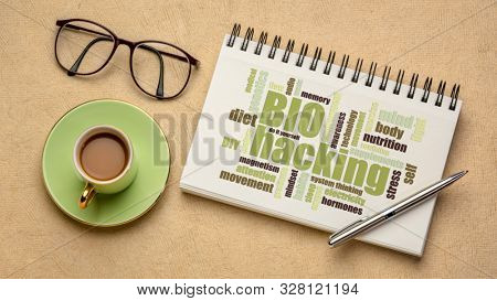 biohacking -  managing one's own biology using a combination of medical, nutritional and electronic techniques - word cloud on a sketchbook with a cup of coffee