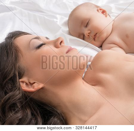 Young Mother And Lovely Baby Boy In Bed
