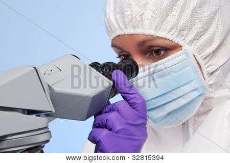 Photo of a biochemist looking through a stereo optical laboratory microscope at a specimen on a slide.
