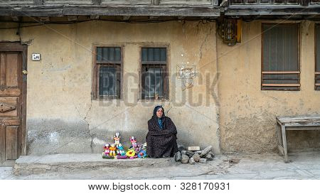 Masuleh, Iran - May 2019: Iranian Woman Selling Hand Made Dolls For Tourists