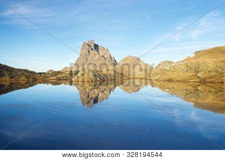 Midi Dossau Peak reflected in a lake. Ossau Valley, Pyrenees National Park, Pyrenees, France.