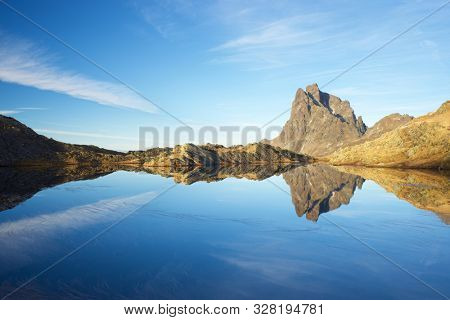 Midi Dossau Peak reflected in a lake. Ossau Valley, Pyrenees National Park, Pyrenees, France.