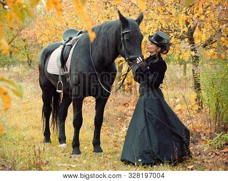 Horsewoman Girl In A Black Dress Leads A Black Horse