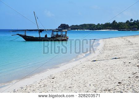 Kendwa, Zanzibar - October 6, 2019:  Blue Transparent Water And Fishing Boat Moored In Indian Ocean,