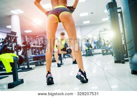 Gorgeous Woman Posing Near Sports Equipment At A Gym Looking Straifht In Front Of Her. Showing Nice 