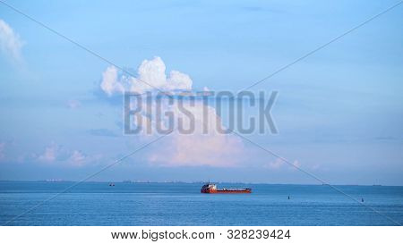 Breathtaking Seascpe With A Sailing Red Barge On Blue Cloudy Sky On The Background, Water Transport 