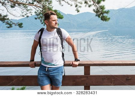 Man portrait on Teletskoye lake in Altai mountains, Siberia, Russia. Beauty summer day.