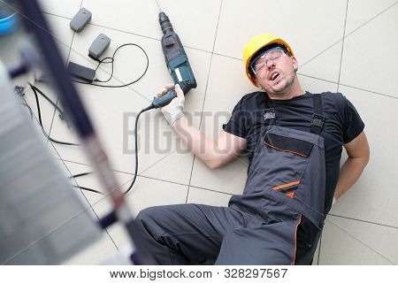 Occupational Safety And Health Concept. Male Worker With Power Tool In His Hands Fell Down Stairs To