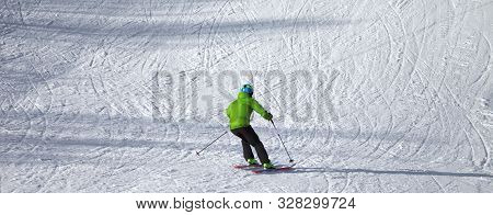 Skier Descent On Snowy Ski Slope With Curves From Skis At Sunny Winter Day. Caucasus Mountains. Hats
