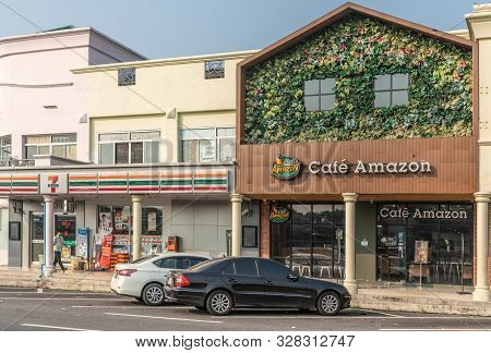 Chachoengsao, Thailand - March 17, 2019: Brown Facade With Green Foliage And Flowers Labeled Café Am