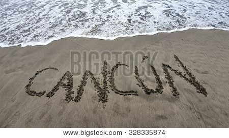 Beach Sand With The Word Cancun Viaje And Water From A Wave Of The Sea