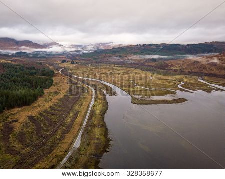 Road Passing Around Loch Eil And Overlooking The Brown Wintery Scottish Highlands On An Overcast Gre