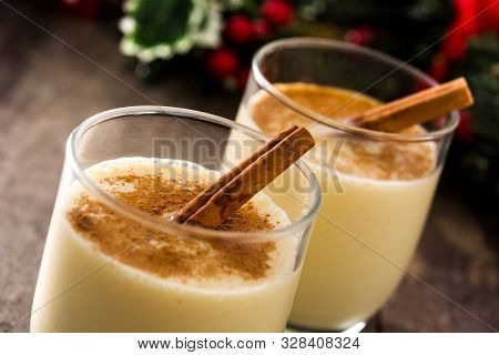 Homemade Eggnog With Cinnamon In Glass On Wooden Table. Typical Christmas Dessert.
