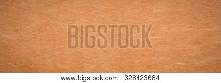 background and texture of ginger yellow Korean hanji paper handmade from inner bark of the mulberry tree, panoramic banner