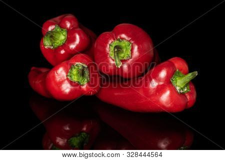 Group Of Four Whole Sweet Red Bell Pepper Isolated On Black Glass