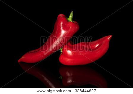 Group Of Two Whole Sweet Red Bell Pepper Isolated On Black Glass