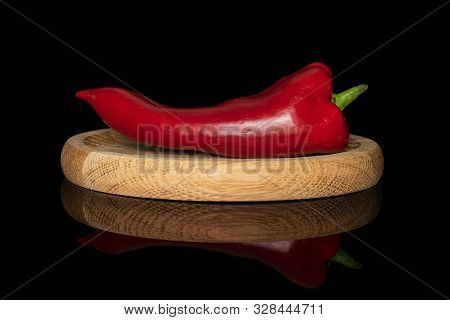 One Whole Sweet Red Bell Pepper On Bamboo Plate Isolated On Black Glass